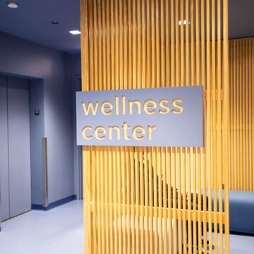 Sign hangs on wall reading “Wellness Center”. 