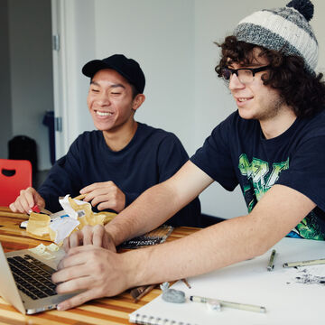 Two students working at a desk. 