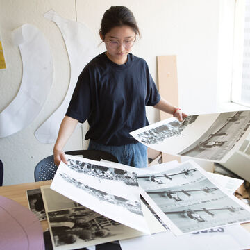 Student holding black and white prints