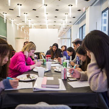 A group of students sits at a table working together.
