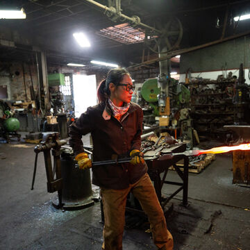 A person in a metal works studio. 