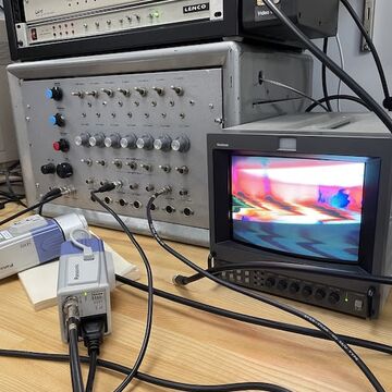 Various computer and sound technology on a table. 