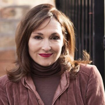 An image of Nora Dunn wearing purple. 