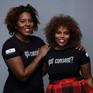 Two people wearing black shirts with white text: "got consent?"