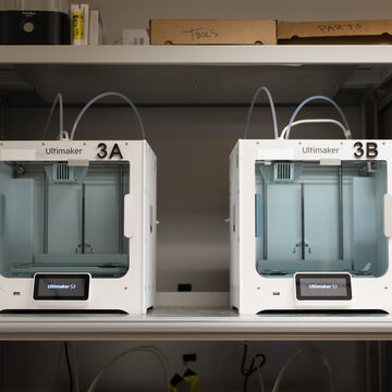 Two 3D printers on a shelf