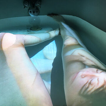 A person’s legs in a tub with a projection over them