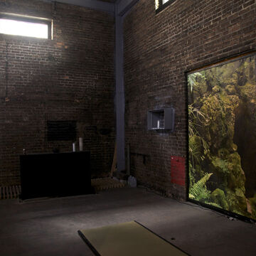 Image of a brick-walled room with an image of a forest in a doorway