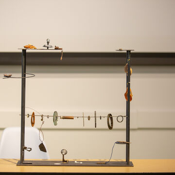 An image of various found, metal objects strung up on a wire. 