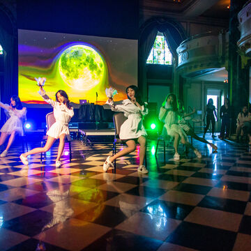 Students dance in front of a projection of the moon at the Chinese Cultural Festival event.