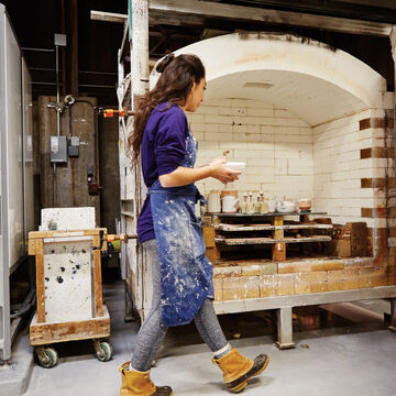 A student walks in front of a kiln