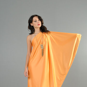 A person wearing a peach, one shoulder draped dress.