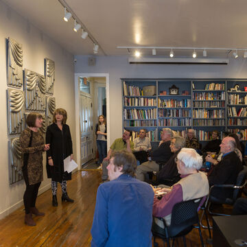 An audience listens to a presentation in the Roger Brown house
