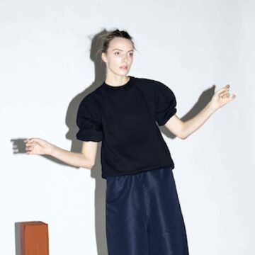 A model wearing a dark navy top with a shimmery navy skirt with silver sandals.