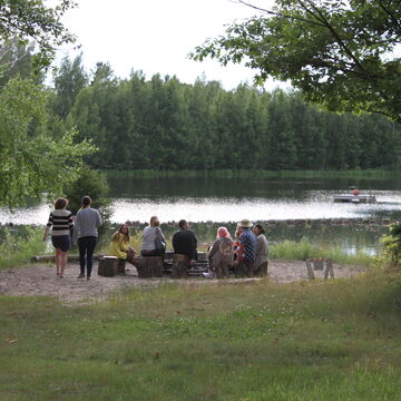 A group of students sitting at a campfire by the lake in Saugatuck, Michigan.