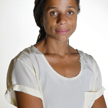 Jina smiling at the camera against a white backdrop