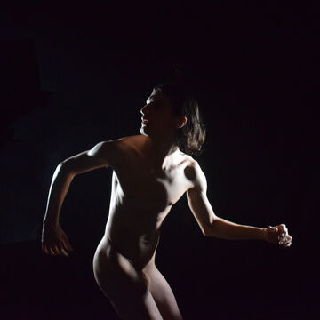 A dimly-lit naked person