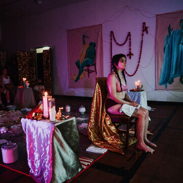 A person sits near the end of an opulent altar