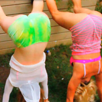 Two people in colorful swimsuits doing handstands
