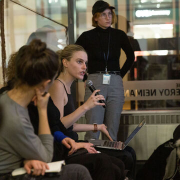 A student at a lecture speaks into a microphone