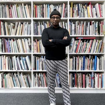 An image of Dawit Petros standing in front of a large bookshelf. 