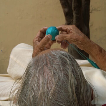An older person playing with a teal ball