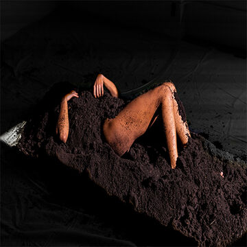 A person buried in dirt, with their arms and legs sticking out