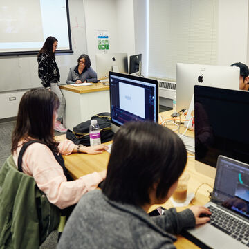 Some students working on their computers in a classroom. 