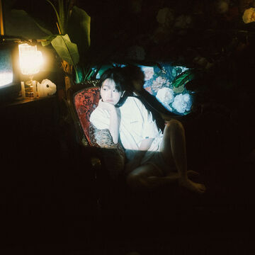 A person in a dimly lit room, looking off-camera