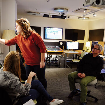 Three people working together in a lab space with multiple screens.