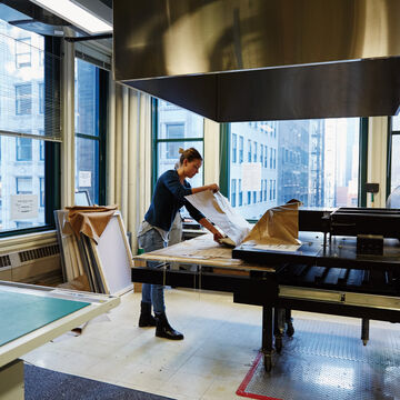 A student wrapping a piece of art at a workstation.