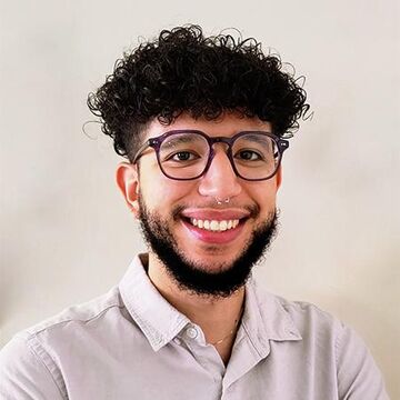 A headshot of Archibaldo "Archi" Lora wearing a white shirt. 