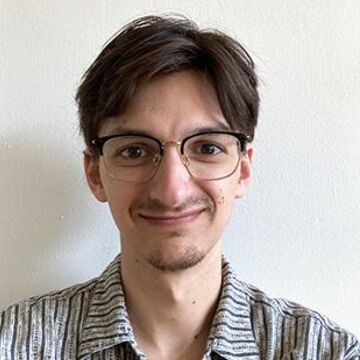 A headshot of Jonathan Korotko in a grey shirt. 