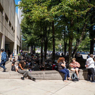 A large gathering of students sitting outside on the SAIC campus.