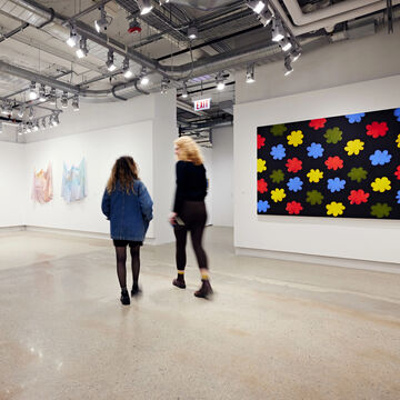 Two students walking around a gallery.