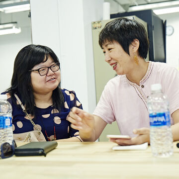 Two people conversing at a table. 