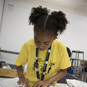 A young student working with foil to create art. 