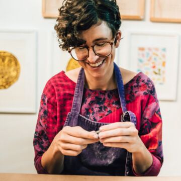 A person smiling while making art 