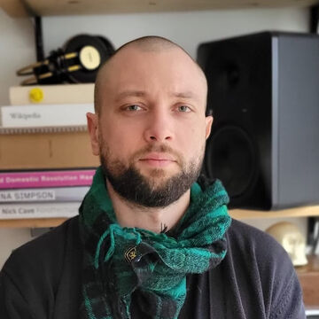 Headshot of a person indoors in front of a bookshelf