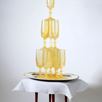 A stack of champagne glasses sits atop a tiny table