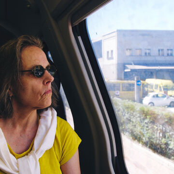 Person looking out window from inside a car