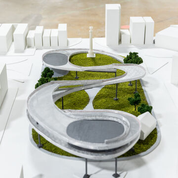 A model of a city scape with a green space in the middle