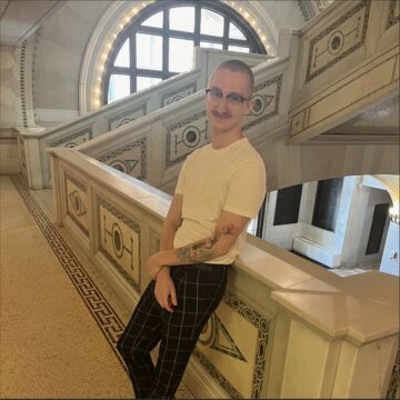 Photograph of Charlie Nawara leaning against a railing at the Chicago Cultural Center