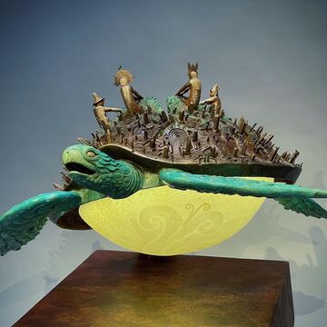 Sculpture by Suni Sonqo Vizcarra Wood of a metropolis on top of a sea turtle