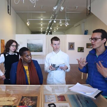 A photo of five people standing in front of a display case