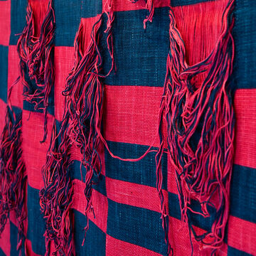 Check pattern weaving of dark blue and pink with certain checks being all fringe.