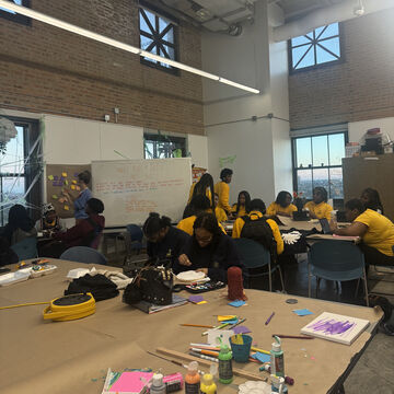 A photo of students doing artwork together at a table