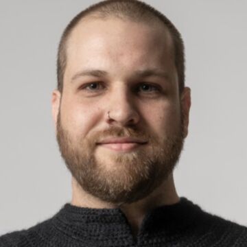 Headshot of Jake Wobig, a fair-skinned adult person with a low haircut.