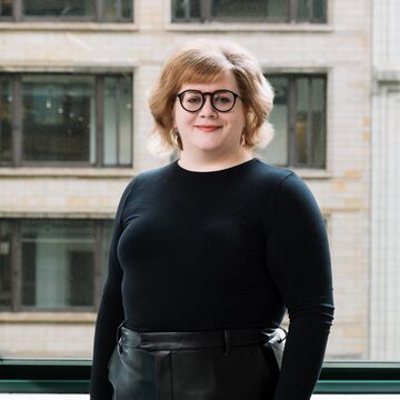 Headshot of Emilie Yardley-Hodges, an adult fair-skinned person with chin-length blonde hair and glasses.