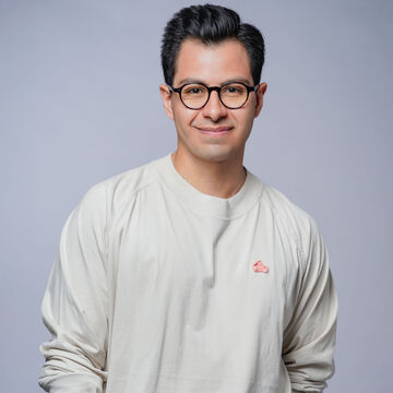 Edgar Aguilera, an adult person with closely-cut black hair, a medium-fair skin tone, and glasses. 