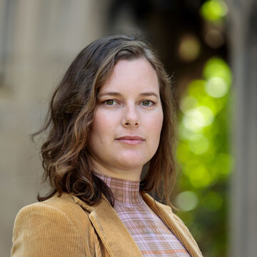 Headshot of Emily Dupree, an adult person with a fair skin tone and fine shoulder-length hair, standing outdoors. 